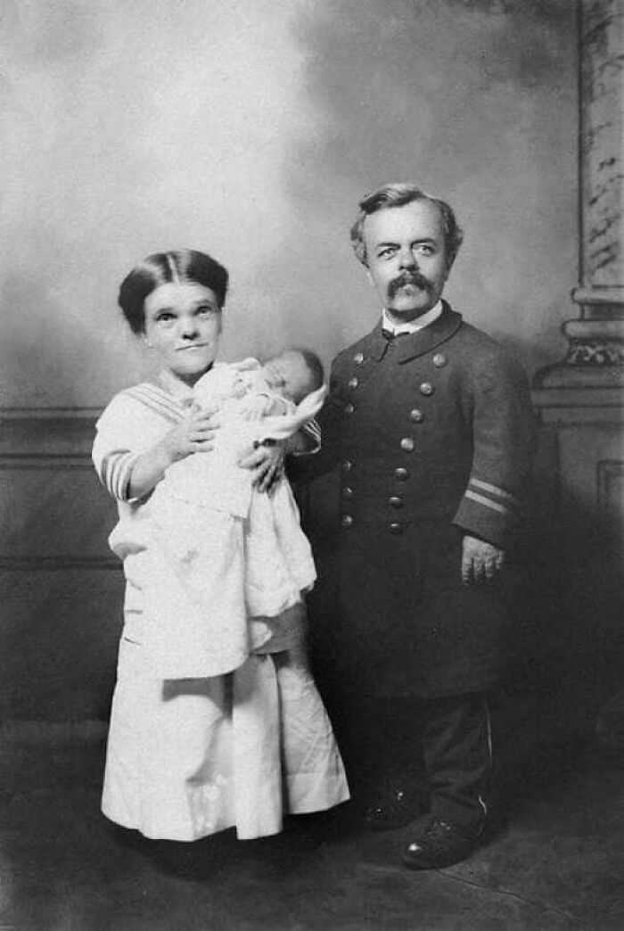 Victorian-era family portrait with a woman holding a baby and a man in uniform.