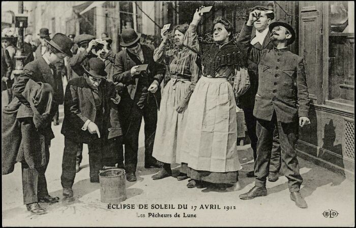 Victorian era people watching a solar eclipse in 1912, with hats and period clothing.