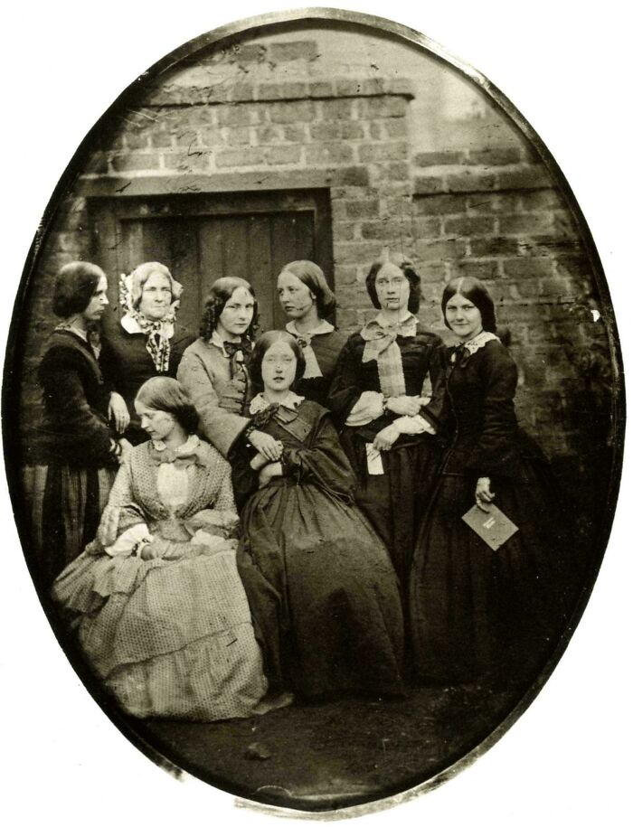 Victorian era women in traditional dresses posing for a group portrait.