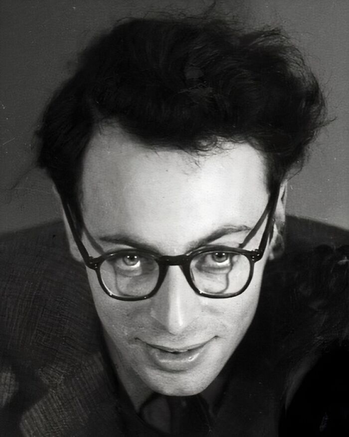 A person from the past wearing glasses, looking upward with a slight smile, capturing a moment of history cool kids.