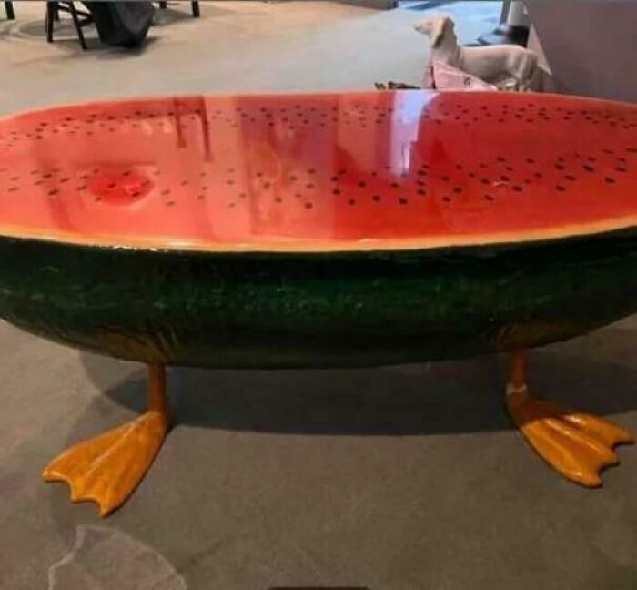 Watermelon-shaped table with duck feet legs, showcasing a funny example of awful taste but great e*******n in furniture design.
