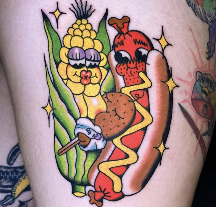 Colorful tattoo of anthropomorphic corn, hot dog, and chicken leg with mustard, showcasing funny awful taste but great e*******n.