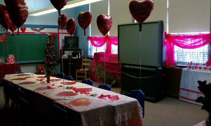 Classroom decorated for Valentine's Day with heart balloons and a chalkboard, evoking old-school memories.