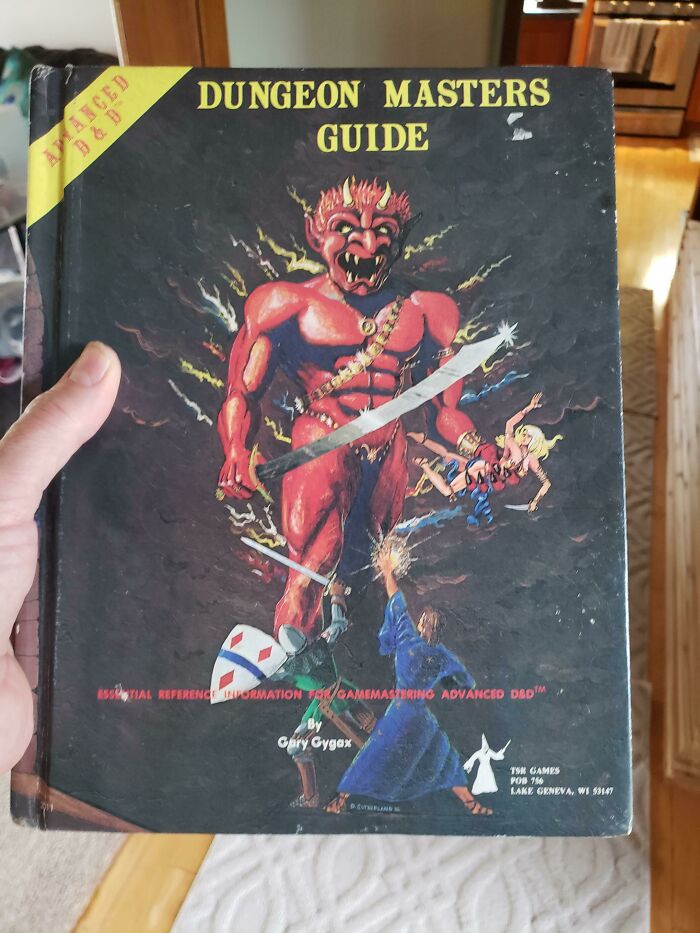 Holding a vintage Dungeon Masters Guide, evoking old-school items and memories.