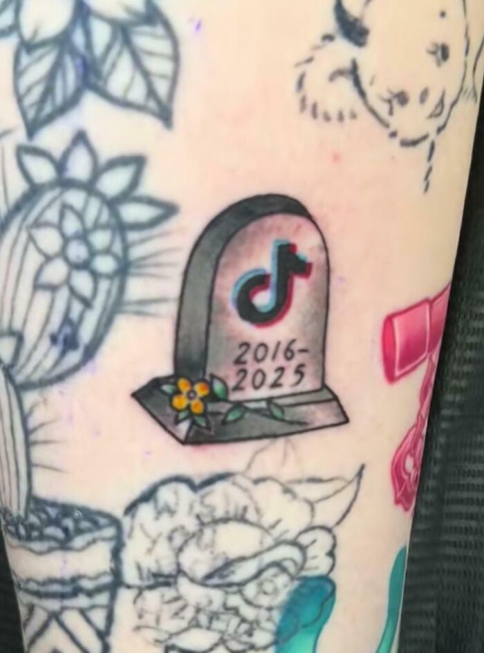 Tattoo of a gravestone with a TikTok logo and dates, symbolizing future predictions aged bad.