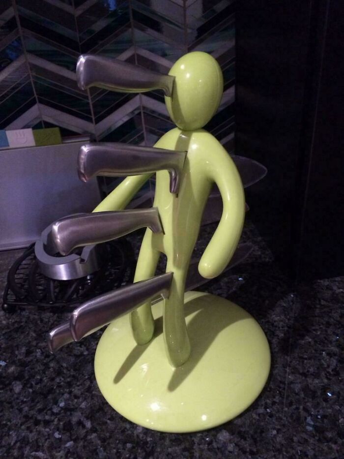 Abstract green figure with knives in a kitchen setting, symbolizing terrible wedding guest behavior.