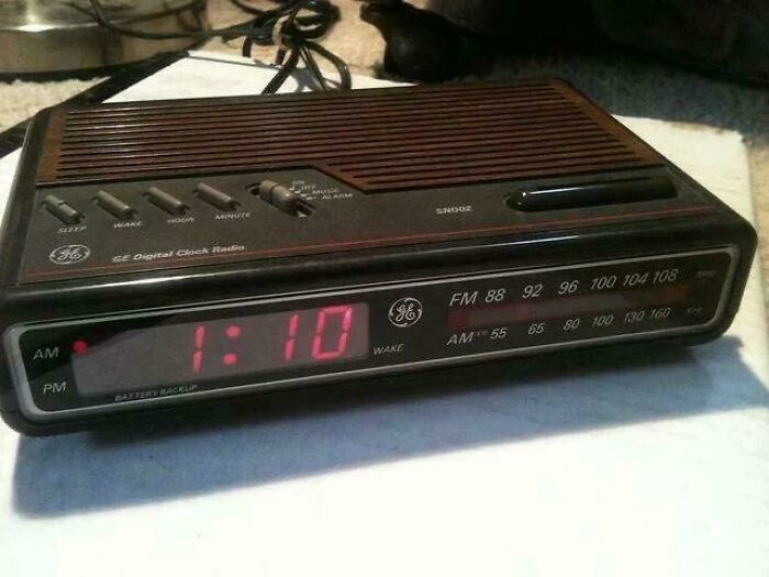 Vintage GE digital clock radio showing time 1:10 with AM and FM radio dials in a nostalgic setting.