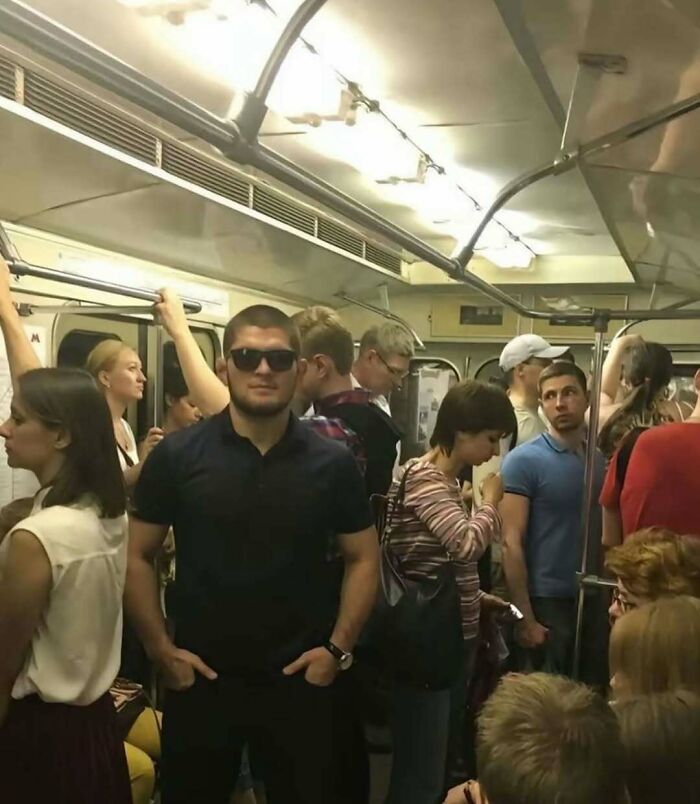 Crowded subway car with diverse passengers standing and sitting, highlighting weird side of the internet moments in photos.