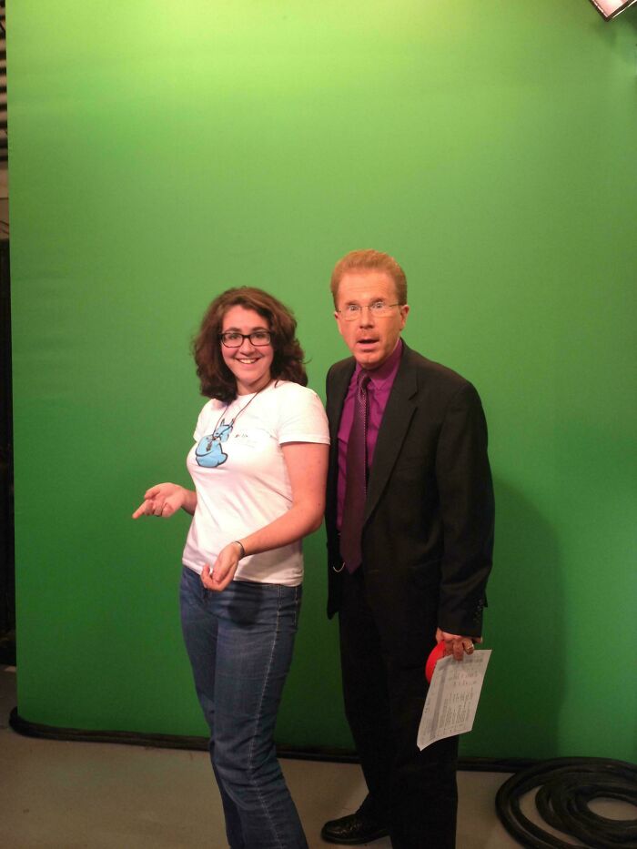 Two people posing awkwardly in front of a green screen, a casual woman and a surprised man in a suit, regrettable past photo.