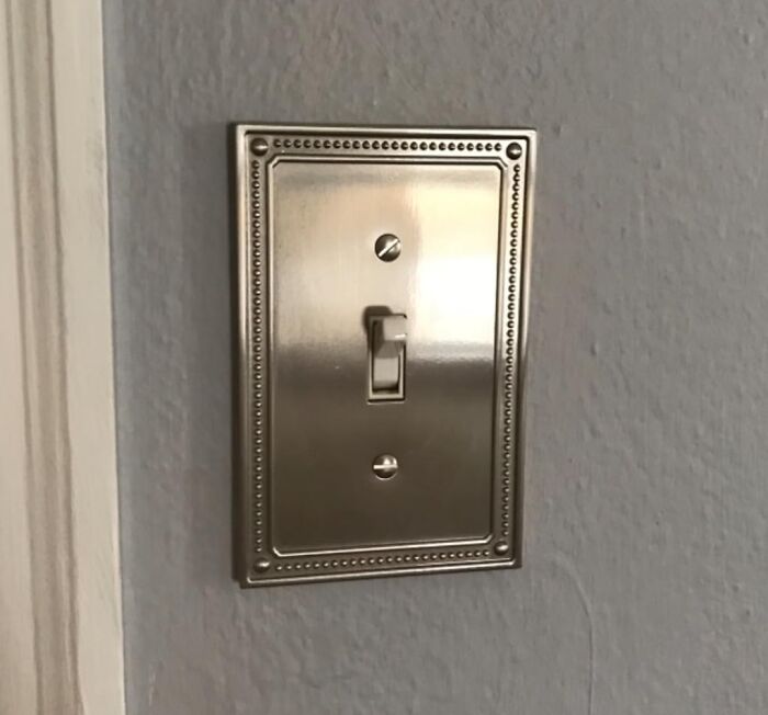 Decorative light switch plate on a wall, showcasing a simple home DIY project for not-handy people.
