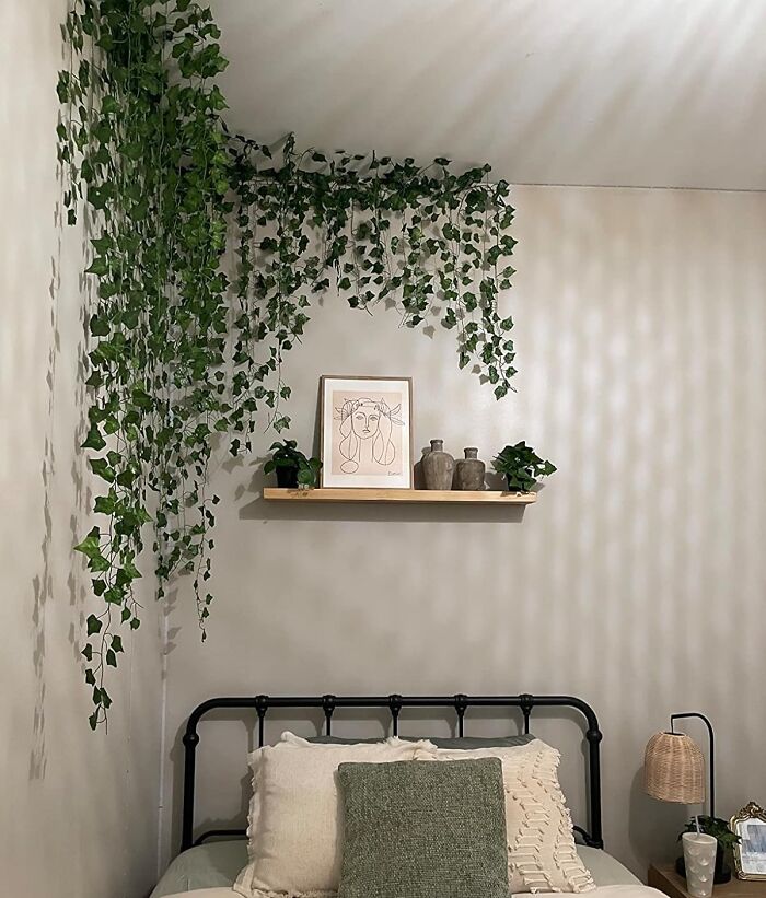DIY bedroom decor with wall vines, shelf art, plants, and cozy bedding for not-handy people.