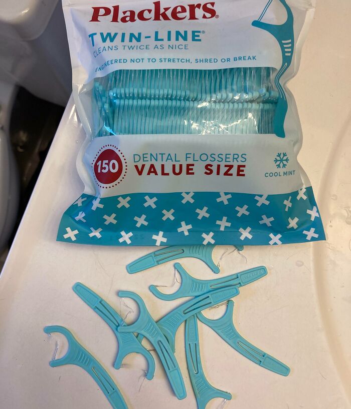 Low-quality dental flossers scattered on a counter with packaging.