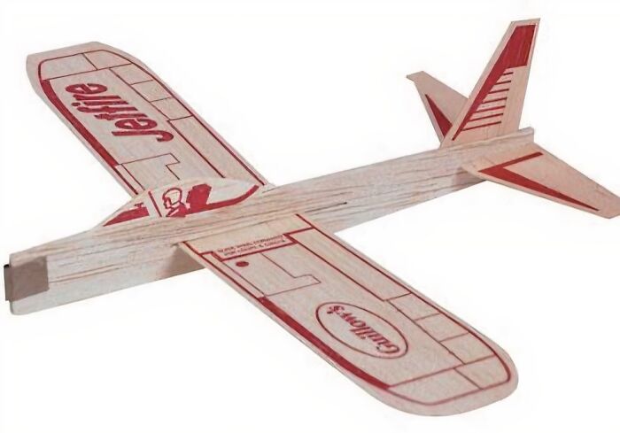 Wooden toy airplane with red designs, reminiscent of childhood memories.