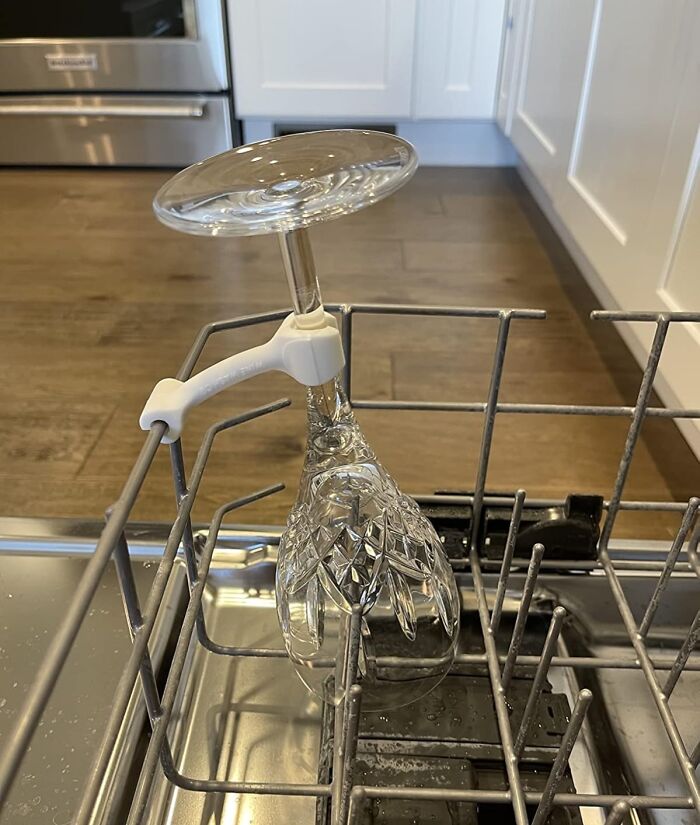 Wine glass secured in dishwasher with a safety clip, showcasing innovative life savers for everyday use.