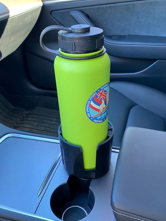 Green water bottle in car holder, showcasing one of the life savers for daily use.