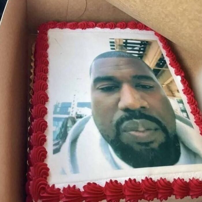 A cake with a printed photo of a man's face, featuring red icing around the edges.