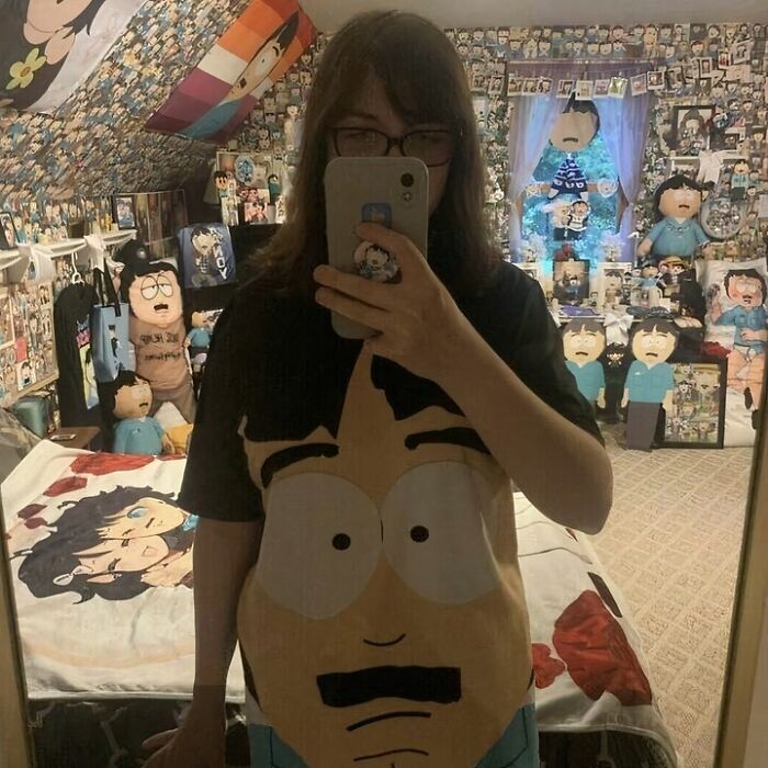 Mirror selfie in a room filled with cartoon posters, featuring funny and confusing décor.
