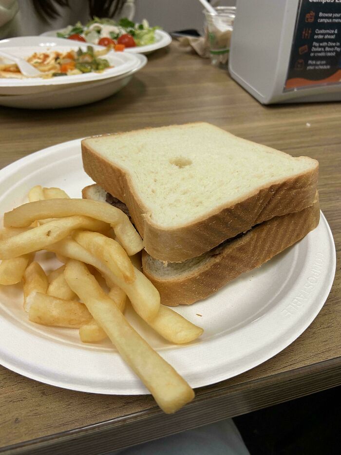 Fries next to a plain sandwich with a hole, illustrating food scams.