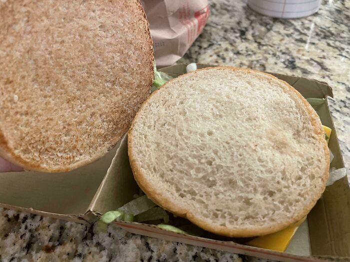 Burger bun with missing patty, highlighting food scams.