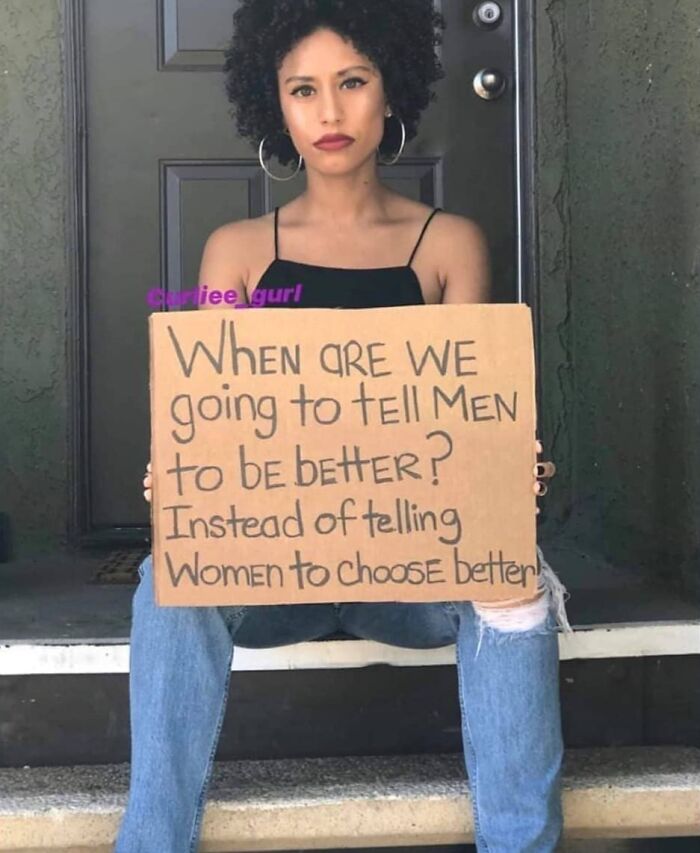 Woman holding a sign about dating frustrations in her 30s, addressing gender expectations on a doorstep.