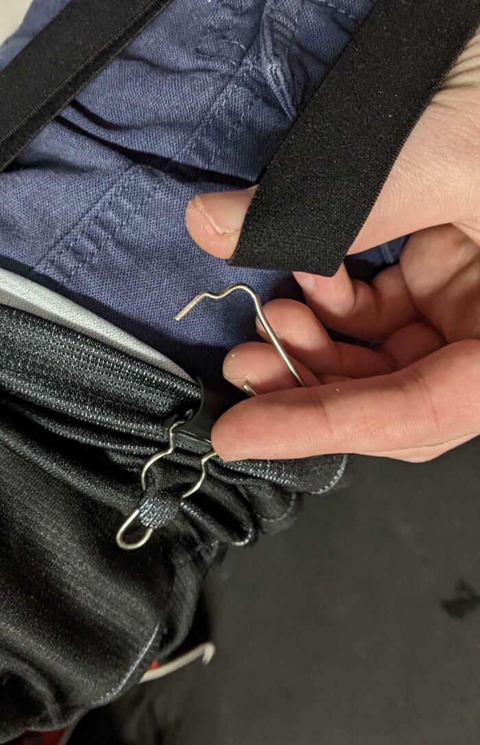 Person holding low-quality item with poorly made metal hook design, showing potential purchase regret.