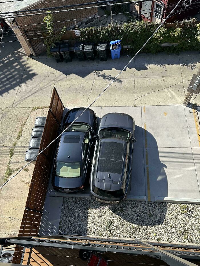 Two cars parked tightly side by side in a driveway, showing neighbors being so horrific people had to shame them.