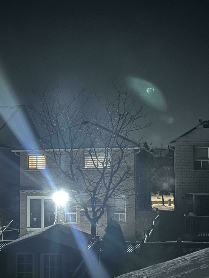 Backyard at night, bright light shining into a house, illustrating terrible neighbors.