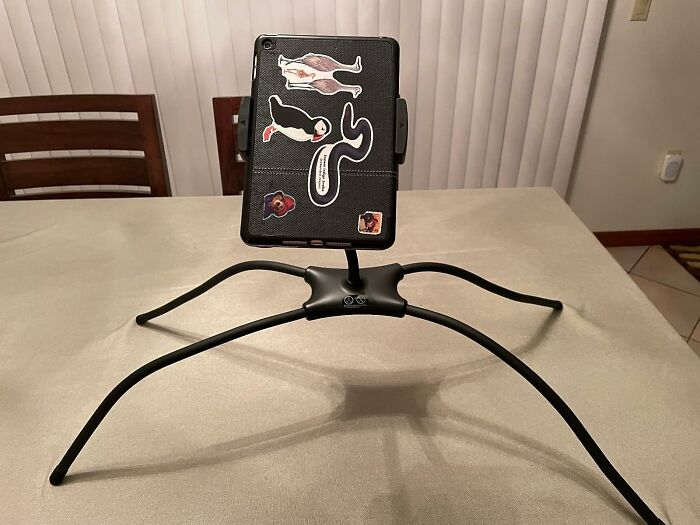 Tablet on a spider-like stand displaying futuristic tech stickers, illustrating time travel tech finds.