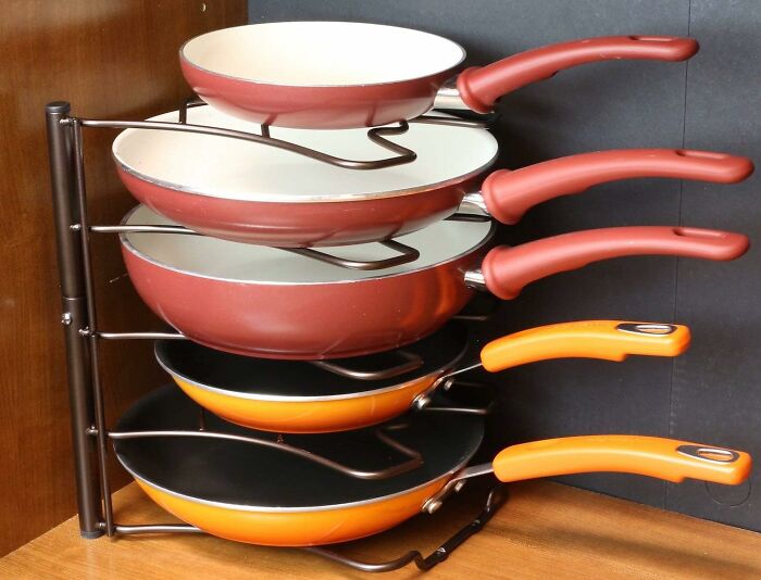 Frying pans with colorful handles organized on a rack, a 5-star kitchen item under $20.
