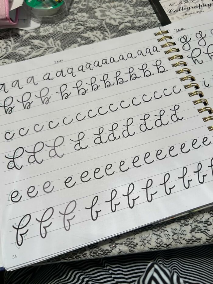 Practice calligraphy as a hobby with a notebook showing cursive letter drills on lined paper.