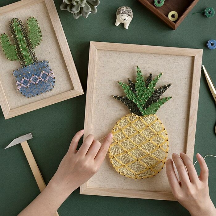 Hands creating string art pineapple and cactus designs as creative hobbies to try when you've reached the end of the internet.