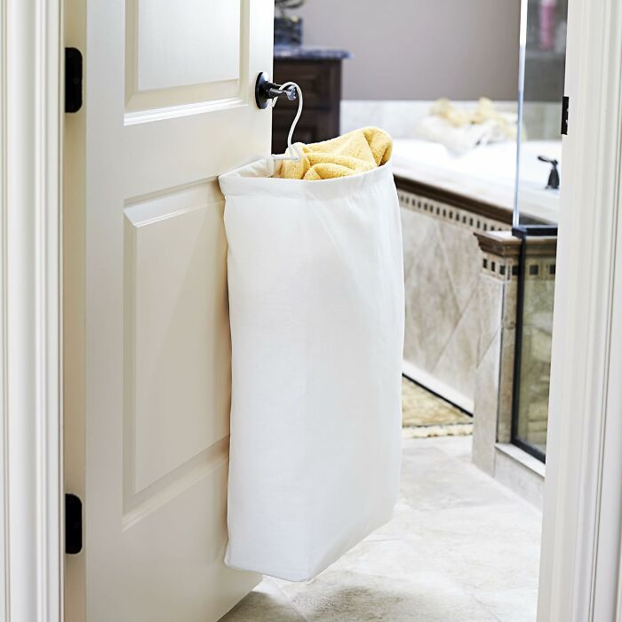 Over-the-door laundry hamper with yellow towel, a budget-friendly storage solution under $20.