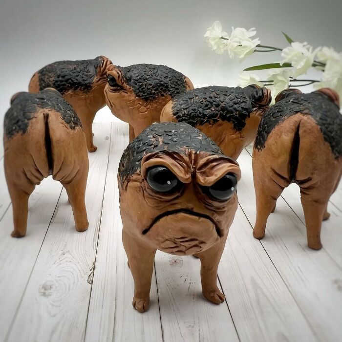 Unusual dog sculptures with human-like faces, showcasing some of the funniest Amazon finds on a wooden floor.