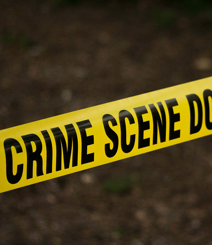 Yellow crime scene tape stretched out with blurred background.