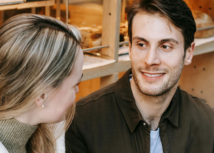 A man smiling warmly at a woman, showcasing a different and genuine connection.