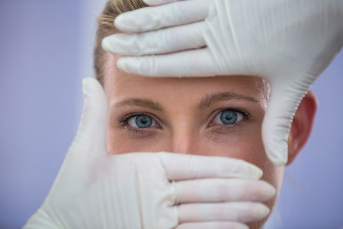 Woman framed by gloved hands, representing how buying these things improved their lives.