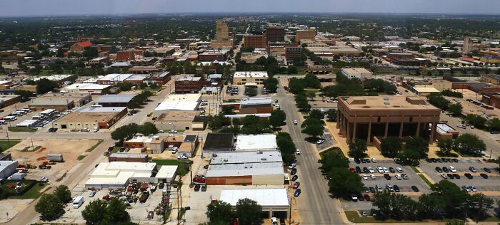 Aerial view of a city with streets and buildings, illustrating a location tied to weird unsolved mysteries.