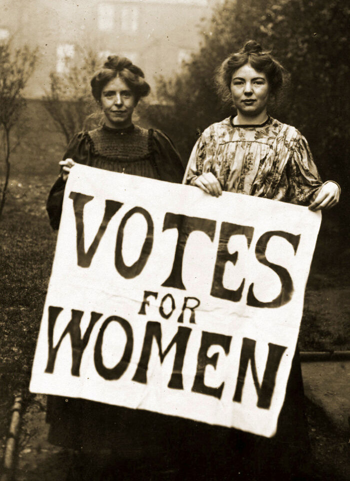 Two women holding a "Votes for Women" sign, highlighting overlooked historical events in the suffrage movement.