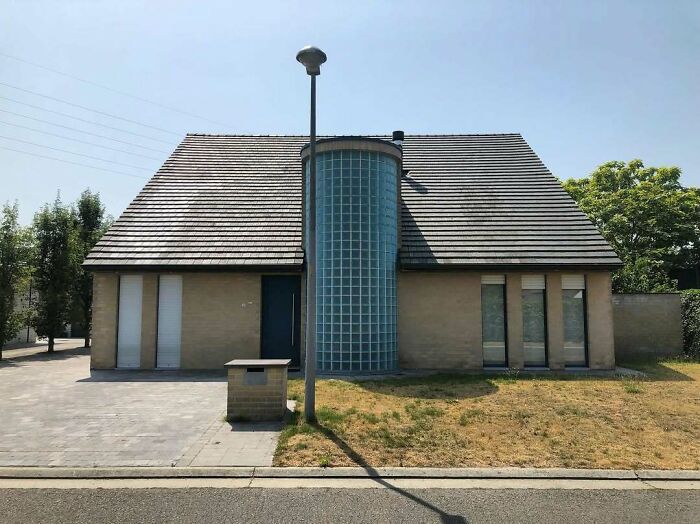 Unusual house design with a central glass block structure, noted for its unconventional architecture.