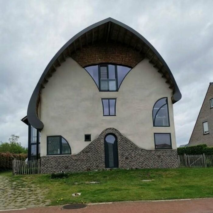 Unusual house design with mismatched windows and an unconventional roof, showcasing hilariously bad architecture.