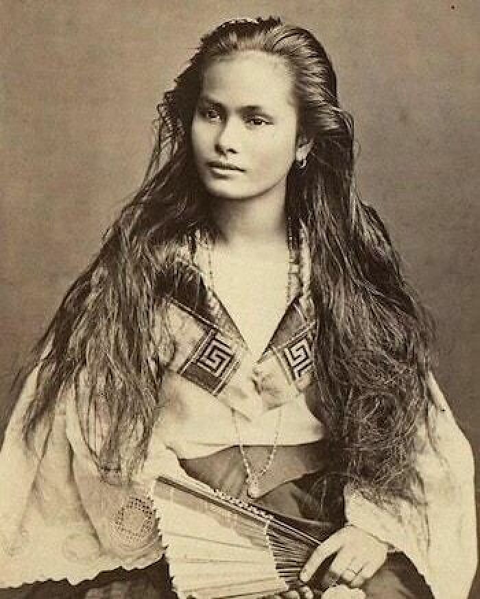 Vintage portrait of a young girl from the past, with long hair, traditional attire, symbolizing history cool kids.