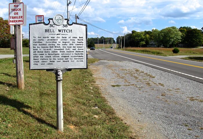 Bell Witch historical marker beside road, highlighting a weird unsolved mystery in an open rural setting.