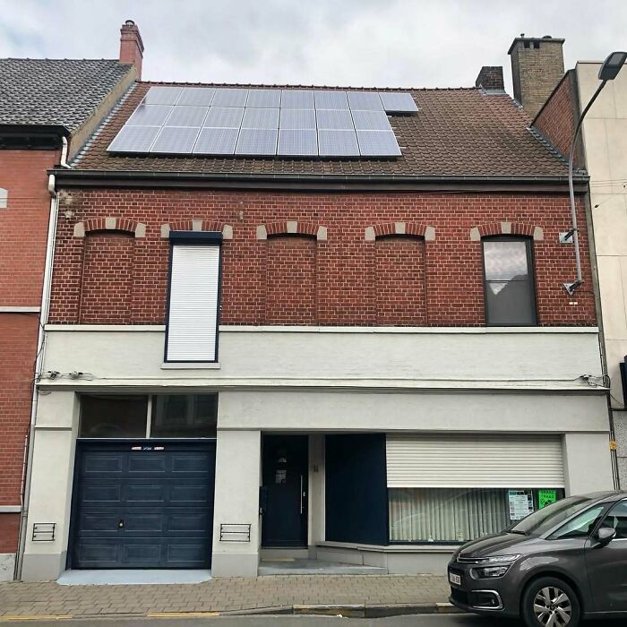Unusual house with uneven windows and solar panels, exemplifying hilariously bad houses in Belgium.