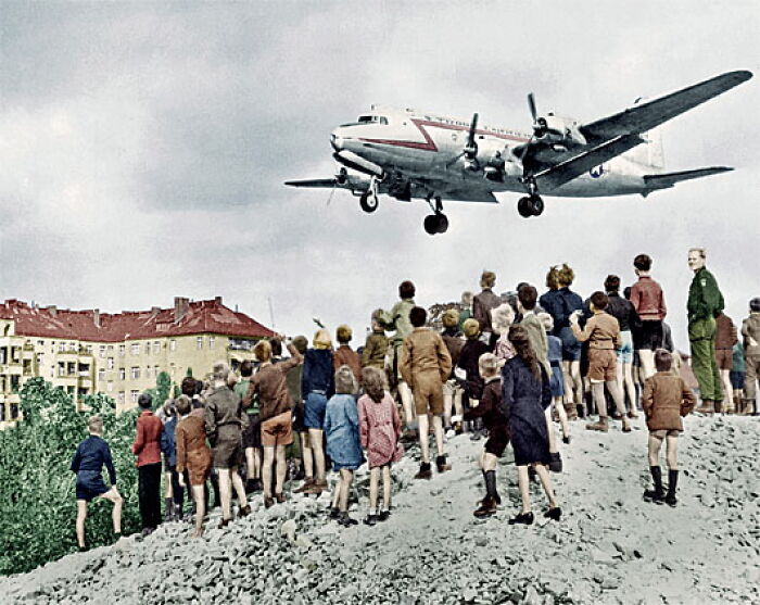 Children watching a plane land, illustrating overlooked historical events.
