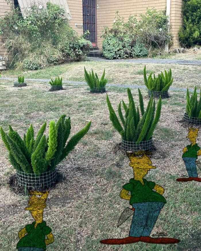 Unique garden design with cartoon character cutouts among lush potted plants in a yard.