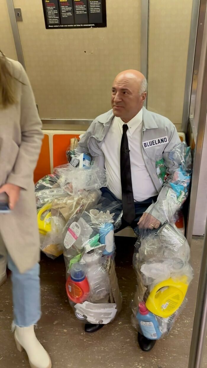 NYC local on train wearing unique fashion outfit made of plastic containers and bags, showcasing experimental style.