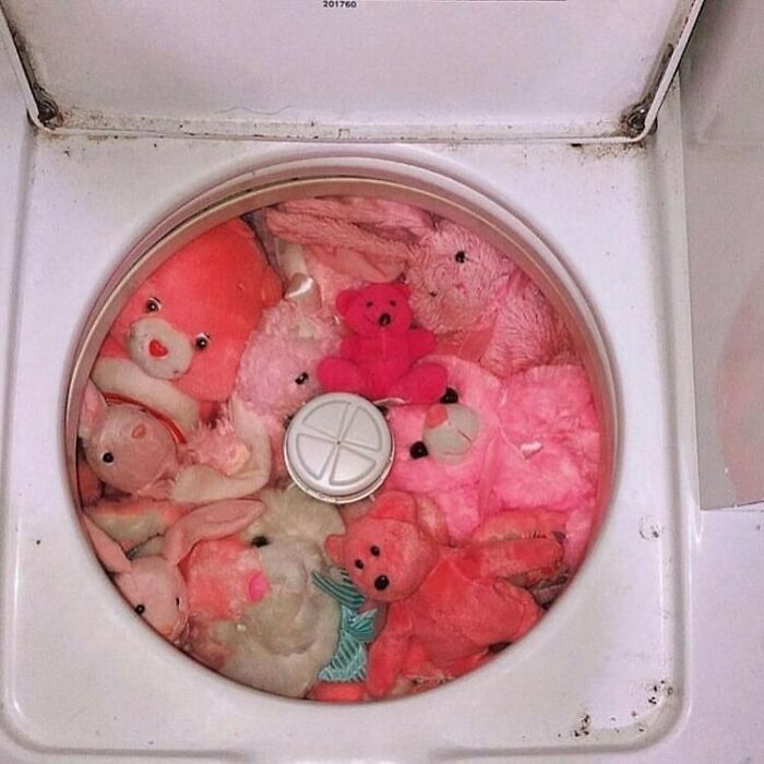 Confusing photo of pink stuffed animals in a washing machine without context.