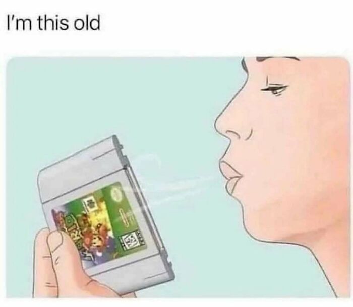 Nostalgic image of a person blowing into a video game cartridge.