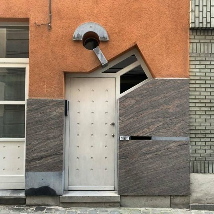 Quirky door design on a modern house with odd geometric shapes and mismatched elements.