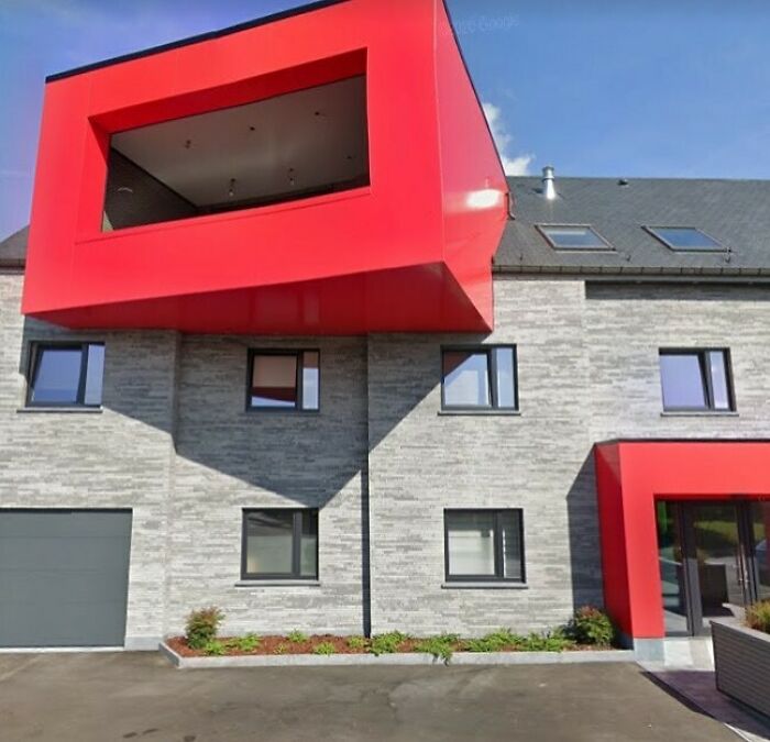 Modern house with unusual red design elements on the facade, showcasing one of the hilariously bad houses.